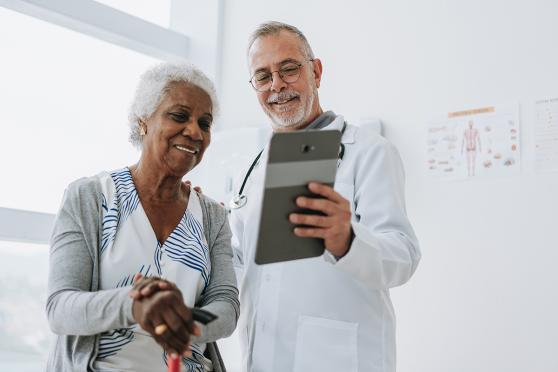 Senior female patient and doctor looking at chart